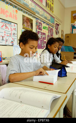 Schüler der Klasse 5 arbeiten an ihren Schreibtischen im Klassenzimmer Stockfoto
