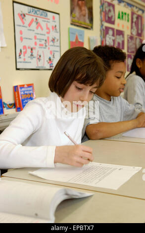 Schüler der Klasse 5 arbeiten an ihren Schreibtischen im Klassenzimmer Stockfoto