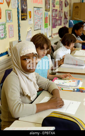 Schüler der Klasse 5 arbeiten an ihren Schreibtischen im Klassenzimmer Stockfoto
