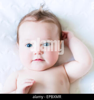 Entzückende blue eyed Baby auf einer weißen Decke stricken Stockfoto