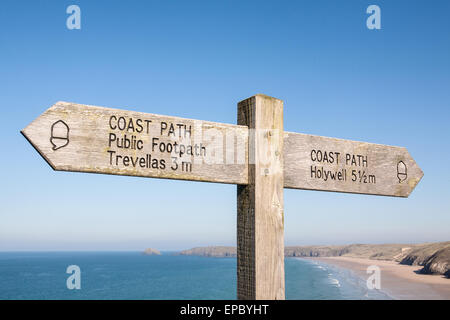 Wegweiser auf South West Coast Path, Großbritanniens längsten Wanderweg und ein National Trail, wie durch das Eichel-Symbol auf dem Schild oben Dünenwanderungen Sand Strand von Perranporth, einem beliebten Badeort in Nord Cornwall, England. Stockfoto