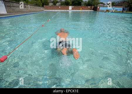 Ein Mann schwimmt in einem Schwimmbad an Pells Pool, der ältesten Süßwasser öffentlichen Außenpool im Vereinigten Königreich, in Lewes, East Sussex, England. Stockfoto