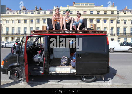 Drei junge Männer trinken Bier auf einem Sofa auf einem Lieferwagen in der Sonne auf Samstag, 16. Mai 2015 in Brighton, UK Stockfoto