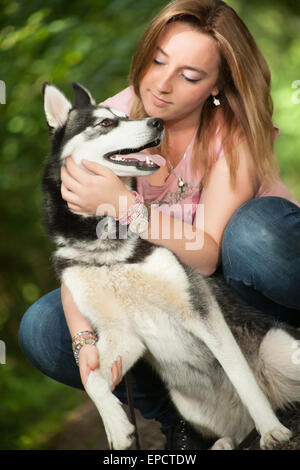 Junge Frau und ihr Husky im Wald Stockfoto