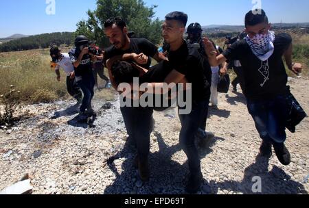 Nablus. 16. Mai 2015. Einen verletzten palästinensischen Demonstrant wird weggetragen, nachdem er mit einer Kautschuk-Kugel abgefeuert durch israelische Militär während der Auseinandersetzungen nach einem Protest Kennzeichnung Nakba Day in der Nähe von Israels Howrah Kontrollpunkt in der Nähe von West Bank Stadt von Nablus, 16. Mai 2015 getroffen wurde. Die Nakba, was bedeutet "Tag der Katastrophe", ist der palästinensischen Tag zum Gedenken an die Vertreibung, die den arabisch-israelischen Krieg 1948 folgten. © Ayman Nobani/Xinhua/Alamy Live-Nachrichten Stockfoto