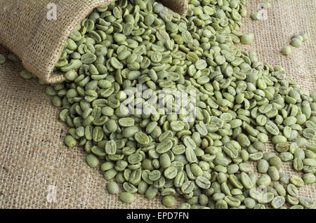 Grüne Kaffeebohnen in Leinensack auf Sackleinen Oberfläche Stockfoto