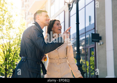 Lächelnd hübschen Mann zeigte auf etwas an die glückliche Ehefrau im freien Stockfoto