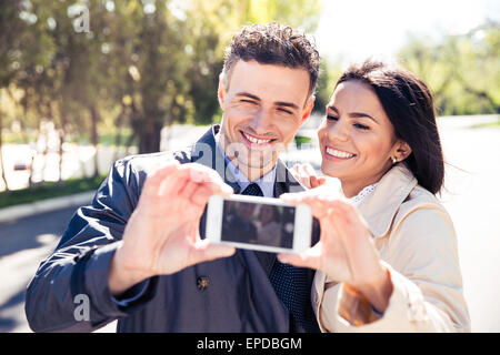 Lächelnde paar machen Selfie Foto auf Smartphone im park Stockfoto