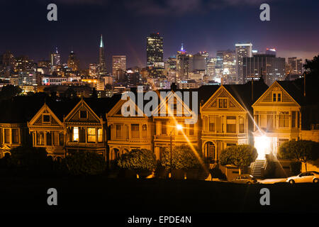 Die Painted Ladies und die Skyline von San Francisco bei Nacht, gesehen vom Alamo Square Park in San Francisco, Kalifornien. Stockfoto