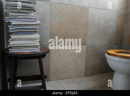 Ein Stapel Zeitschriften auf einem Tisch in einer Toilette Stockfoto