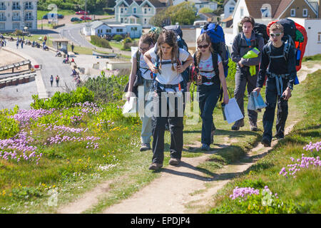 Gruppe junger Leute, die im Mai auf den Süßwasser-Klippen auf der Isle of Wight, Hampshire, Großbritannien, spazieren Stockfoto