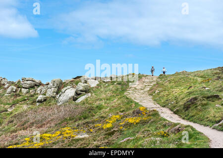 Zwei Menschen, die zu Fuß entlang der South West Coast Path zwischen Sennen Cove und Lands End in Cornwall, England, UK Stockfoto