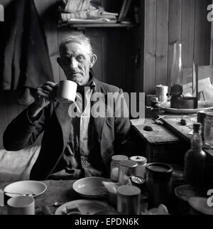 1950er-Jahren, historische Porträt des Halters an Farne Islands vor der Küste von Northumberland, Teetrinken in seine kleine Wohnung. Stockfoto