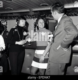 1960er Jahre, historische, Gentleman mit Kamera um den Hals, plaudert mit zwei Damen in einer Hotelbar. Stockfoto