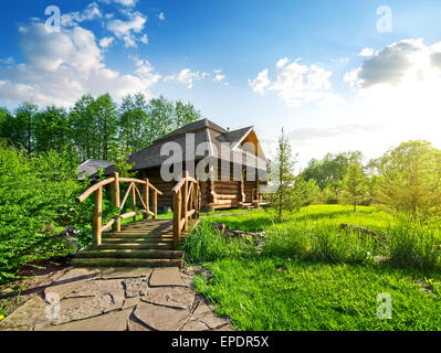 Holzbrücke und Haus der Log im Wald Stockfoto