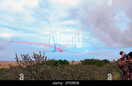 ROTE PFEILE FLIEGEN DURCH IHRE WIRBELNDEN FARBIGEN RAUCH STUDIEN. Stockfoto