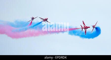 ROTE PFEILE FLIEGEN DURCH IHRE WIRBELNDEN FARBIGEN RAUCH STUDIEN. Stockfoto