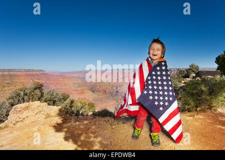 Fröhlicher Junge gebündelt in USA-Flagge, Grand Canyon Stockfoto