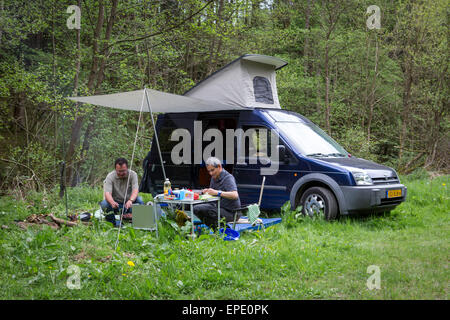 Zwei Männer kochen und Camping mit ihren Ford Transit Connect Camper in der Wildnis Stockfoto