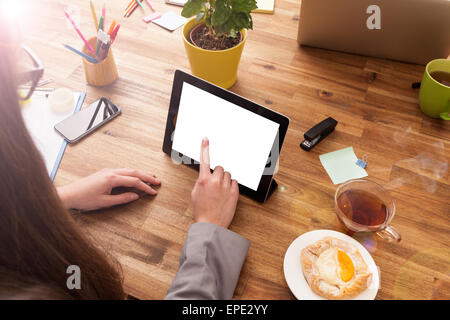 Junge Frau mit Tablet auf hölzernen Schreibtisch mit leeren Bildschirm für Text platziert. Schuss aus Vogelperspektive Stockfoto