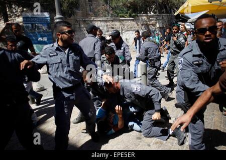 Jerusalem. 17. Mai 2015. Ein palästinensischen Demonstranten ist von der israelischen Polizei festgenommen, als Juden durch Damaskus-Tor in der Altstadt von Jerusalem, am 17. Mai 2015 März. Zehntausende von Juden marschierten Sonntag durch muslimische Viertel Ost-Jerusalem, Funkenbildung Schlägereien zwischen Palästinensern und der Polizei. Die umstrittene März feierte Israels 48. Jerusalem-Tag, Kennzeichnung der "Wiedervereinigung" der Stadt, nachdem Israel Nahost-Krieg von 1967 die arabischen Ostteil der Stadt erobert. © Muammar Awad/Xinhua/Alamy Live-Nachrichten Stockfoto