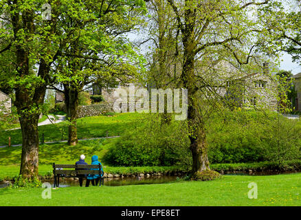 Paar auf Bank in das Dorf von Linton, Wharfedale, Yorkshire Dales National Park, North Yorkshire, England UK Stockfoto