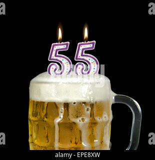 Geburtstagskerzen in Krug Bier zum 55. Geburtstag isoliert auf schwarz. Stockfoto