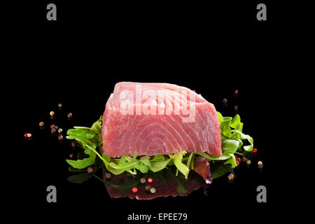 Rohen Thunfisch-Steak auf schwarzem Hintergrund isoliert. Traditionellen Meeresfrüchte essen. Sashimi Sushi. Stockfoto