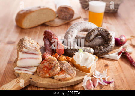 Blutwurst, Reis Wurst, Kopf Käse, Knoblauch, Zwiebel-Bier und Brot auf Holzküche Brett auf hölzernen Hintergrund. Stockfoto