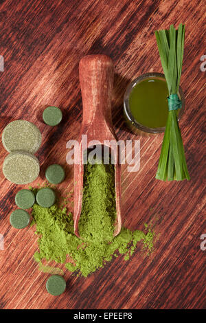 Detox. Chlorella, Spirulina, Weizengras und Gerste grass Pillen, Tabletten, Grashalme und Grundpuder auf hölzernen Hintergrund. Stockfoto