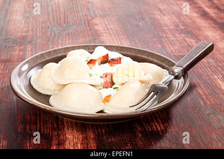 Brinsennockerl Pirohy. Knödel mit Schafen Käse Bryndza auf braune Teller auf braunem Hintergrund aus Holz. Traditionelle slowakische Küche. Stockfoto