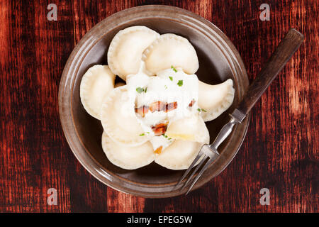 Brinsennockerl Pirohy. Knödel mit Schafen Käse Bryndza auf braune Teller auf braunem Hintergrund aus Holz. Traditionelle slowakische Küche. Stockfoto