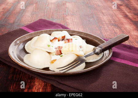 Brinsennockerl Pirohy. Knödel mit Schafen Käse Bryndza auf braune Teller auf braunem Hintergrund aus Holz. Traditionelle slowakische Küche. Stockfoto