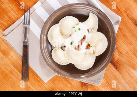 Brinsennockerl Pirohy. Knödel mit Schafen Käse Bryndza auf braune Teller auf braunem Hintergrund aus Holz. Traditionelle slowakische Küche. Stockfoto