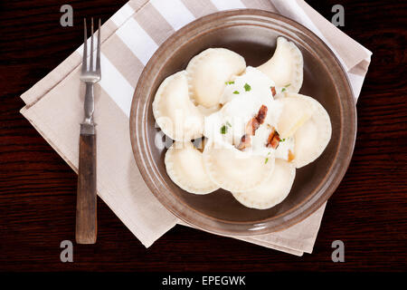 Brinsennockerl Pirohy. Knödel mit Schafen Käse Bryndza auf braune Teller auf braunem Hintergrund aus Holz. Traditionelle slowakische Küche. Stockfoto