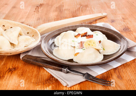 Brinsennockerl Pirohy auf Teller und hölzerne Schaufel auf braunem Hintergrund aus Holz. Traditionellen osteuropäischen Essen, Landhausstil. Stockfoto