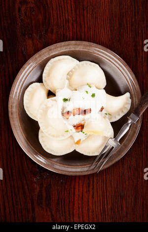 Brinsennockerl Pirohy. Knödel mit Schafen Käse Bryndza auf braune Teller auf braunem Hintergrund aus Holz. Traditionelle slowakische Küche. Stockfoto