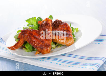 Leckere Buffalo Wings auf Teller mit frischen grünen Salat. Kulinarisches Essen, USA-Küche. Hähnchenflügel. Stockfoto