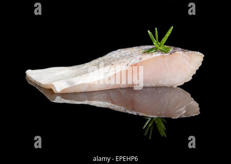 Frische Barsche Fischen Filet isoliert auf schwarzem Hintergrund mit frischen grünen Kräutern. Kulinarischen Meeresfrüchte essen. Stockfoto
