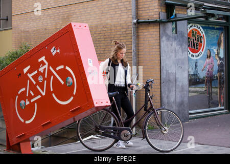 Frau, die ihr Fahrrad aus dem Amsterdam Fahrrad Park Stockfoto