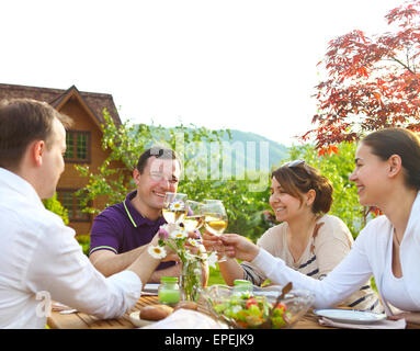 Gruppe der happy Friends Toasten Weingläser im Garten Stockfoto
