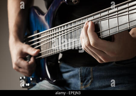 männliche Musiker spielen auf 6-Saiter e-Bass Stockfoto