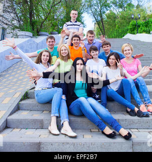 Gruppe von lächelnden Jugendliche sitzen auf der Treppe Stockfoto