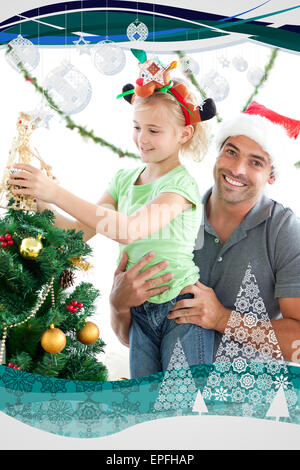 Glücklicher Vater seine Tochter, einen Engel auf den Weihnachtsbaum zu helfen Stockfoto