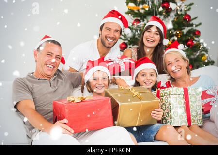 Zusammengesetztes Bild der glücklichen Familie zu Weihnachten Geschenke halten Stockfoto