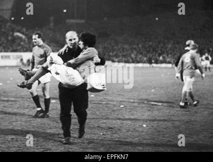 Manchester United Fußballer George Best ist neben dem Spielfeld durch Trainer Jack Crompton geholfen, immer verletzt, während das Ligaspiel gegen Sheffield Mittwoch in Hillsborough. 10. April 1967. Stockfoto