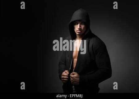 starker Mann tragen Hoodie isoliert auf schwarz Stockfoto