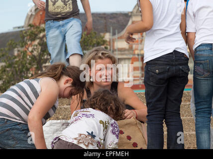 Junge Polin sieht ein wenig unglücklich/besorgt von Kindern umgeben Stockfoto