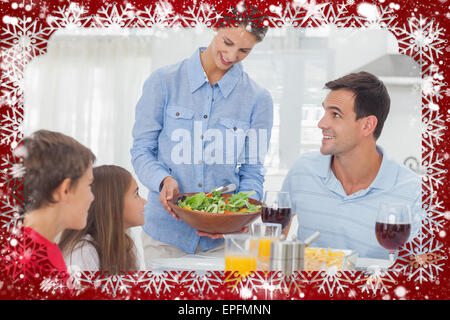 Hübsche Frau bringt einen Salat zu ihrer Familie Stockfoto