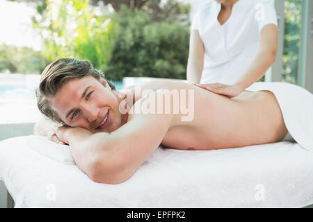 Gut aussehender Mann empfangen Rückenmassage im Wellnesscenter Stockfoto